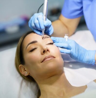 pezialistin für Permanent Make-up korrigiert die Augenbrauen einer Kundin